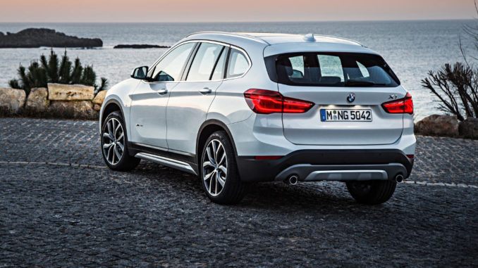 Ein weißer BMW X1 steht 2017 auf einem Parkplatz am Meer.