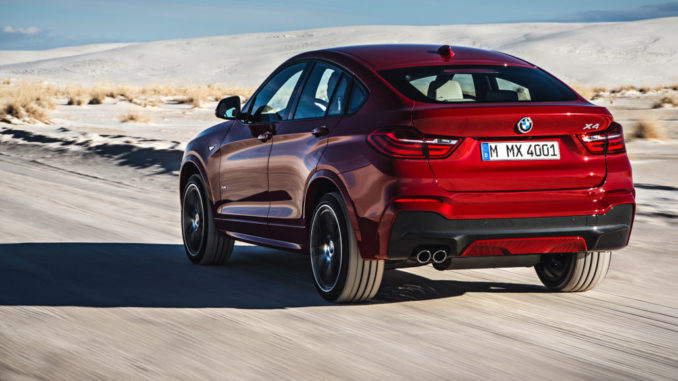 Der neue BMW X4 mit M Sport Paket - Melbourne Rot metallic (02/14) fährt durch eine Wüstenlandschaft.