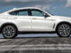 Ein weißer BMW X6 xDrive50i (F16 von 10/2014) aufgenommen im Profil steht auf einer Asphaltfläche mit Reifenspuren.