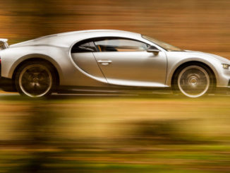 Ein silberner Bugatti Ciron fährt durch einen herbstlichen Wald.