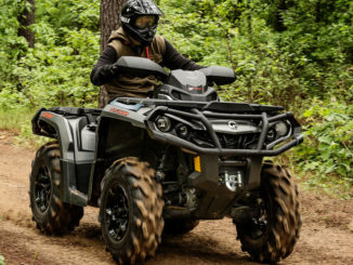 Ein ATV Can-Am Outlander fährt auf einem Waldweg.