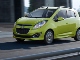 Ein hellgrüner Chevrolet Spark fährt 2014 auf einer Autobahnauffahrt.