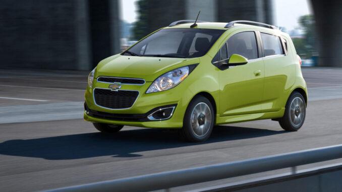 Ein hellgrüner Chevrolet Spark fährt 2014 auf einer Autobahnauffahrt.