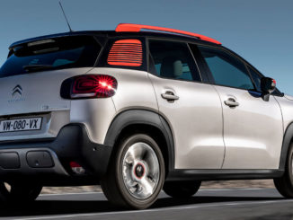 Ein weiß-roter Citroen C3 Aircross fährt durch eine Wüstenlandschaft.