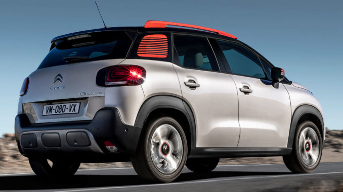 Ein weiß-roter Citroen C3 Aircross fährt durch eine Wüstenlandschaft.