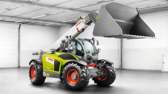 Ein grüner Teleskoplader vom Typ Claas Scorpion steht in einer Halle.