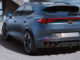 Ein blaugrauer Cupra Formentor fährt 2020 an einem futuristischen Gebäude vorbei.