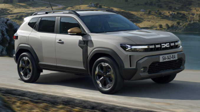 Ein grauer Dacia Duster fährt 2023 durch eine Berglandschaft.