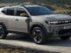 Ein grauer Dacia Duster fährt 2023 durch eine Berglandschaft.