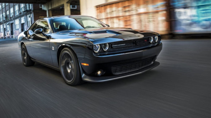 Ein schwarzer Dodge Challenger fährt auf einer Straße einer US-amerikanischen Stadt.