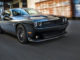 Ein schwarzer Dodge Challenger fährt auf einer Straße einer US-amerikanischen Stadt.