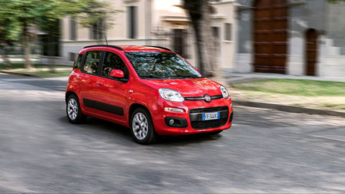 Ein roter Fiat Panda fährt 2016 durch eine italienische Stadt.