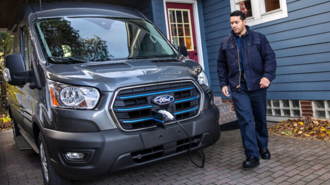 Ein grauer E-Transit wird an einem Einfamilienhaus geladen.