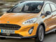 Ein orangener Ford Fiesta Active fährt 2018 auf einer Landstraße.