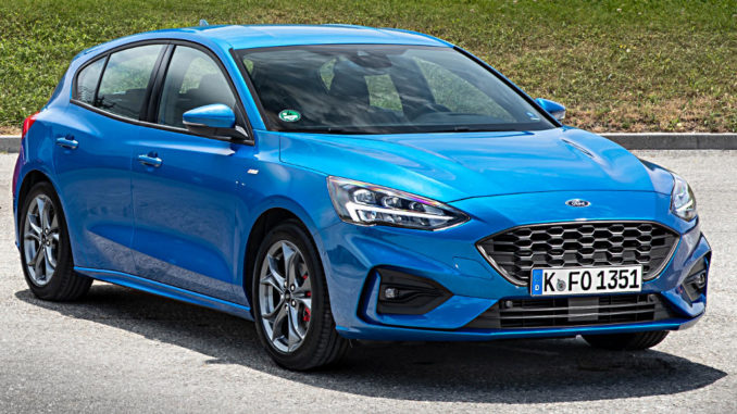 Ein blauer Ford Focus der vierten Generation steht 2018 vor einem Grashügel.