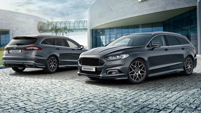 Zwei graue Ford Mondeo Turnier stehen 2015 auf dem gepflasterten Vorplatz eines modernen Gebäudes.