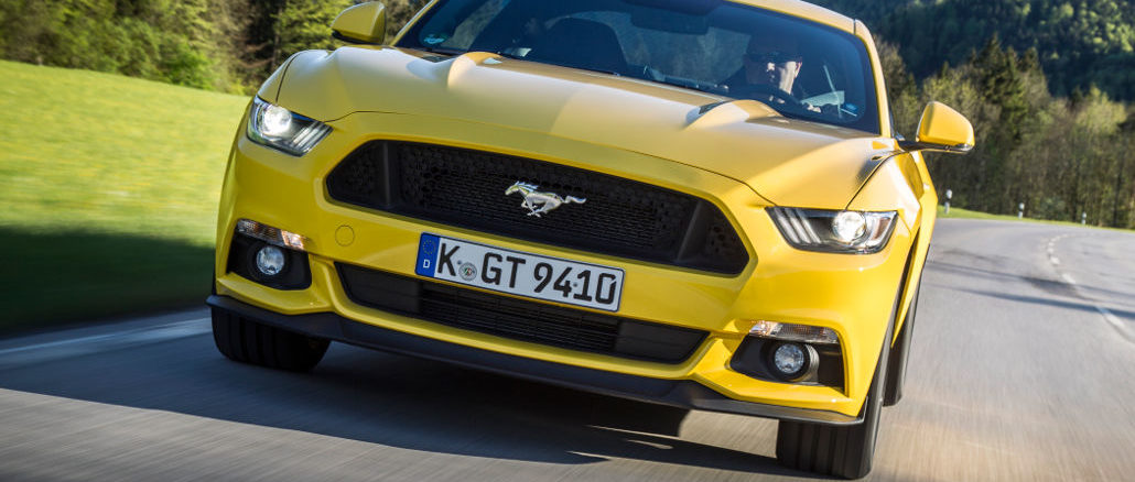 Ein gelber Ford Mustang fährt 2015 durch die Voralpenlandschaft.Mehr als 10.000 Ford Mustang haben Kunden europaweit seit Ende 2014 bestellt. Im Dezember des vergangenen Jahres waren die Auftragsbücher für den Sportwagen geöffnet worden.