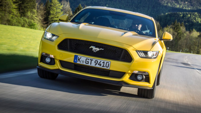 Ein gelber Ford Mustang fährt 2015 durch die Voralpenlandschaft.Mehr als 10.000 Ford Mustang haben Kunden europaweit seit Ende 2014 bestellt. Im Dezember des vergangenen Jahres waren die Auftragsbücher für den Sportwagen geöffnet worden.