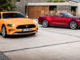Ein oragenes Ford Mustang Coupé und ein rotes Cabrio stehen 2017 vor einer Villa.