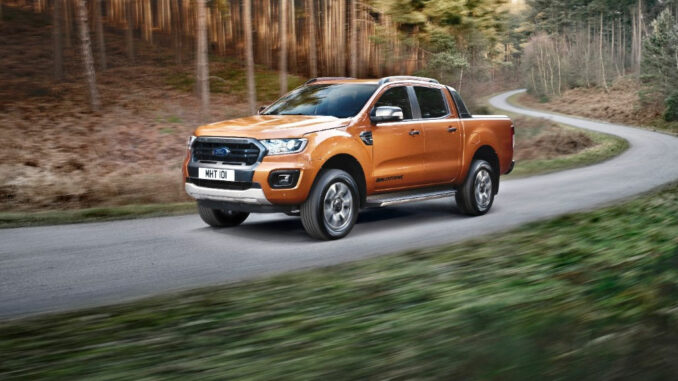 Ein bronzefarbener Ford Ranger Wildtrak fährt 2019 durch den Wald.