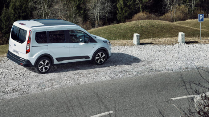 ford_transit_connect_2019 Ein weißer Ford Transit Connect steht 2019 auf dem Parkplatz einer Passstraße.