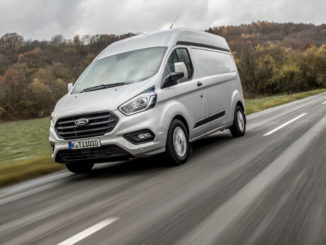 Ein silberner Ford Transit Custom fährt 2017 über eine Landstraße.