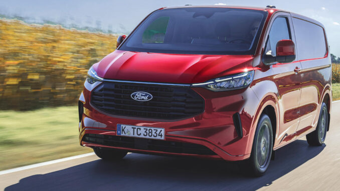 Ein roter Ford Transit Custom fährt 2023 auf einer Landstarße.