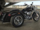 Ein schwarzes Harley-Davidson Trike vom Typ Freewheeler steht 2019 auf einem überdachten Vorplatz.