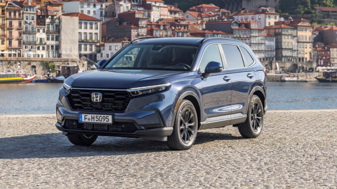 Ein blauer Honda CR-V e:HEV Elegance steht 2023 vor einem Hafen.