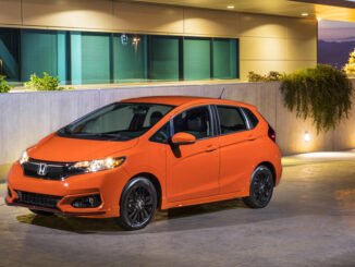 Ein orangener Honda Fit steht 2019 an einer Hausauffahrt.