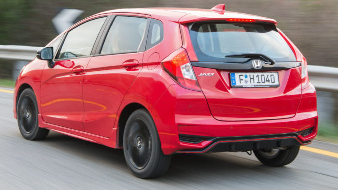 Ein roter Honda Jazz fährt eine Landstraße bergauf (Images of 2018 Jazz Dynamic 1.5-litre i-VTEC).