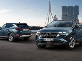 Zwei blaue Hyundai Tucson stehen 2020 vor einer Großstadtshilouette.