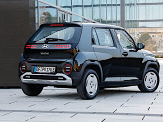 Ein schwarzer Hyundai Inster MY 2025 steht vor einem Bürogebäude.