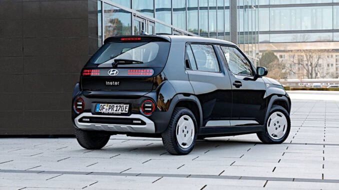 Ein schwarzer Hyundai Inster MY 2025 steht vor einem Bürogebäude.