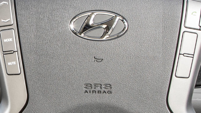 Lenkrad mit Hyundai-Logo, Hupen- und Airbag-Symbol in Großaufnahme.