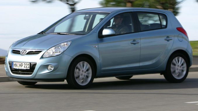 Ein silberner Hyundai i20 fährt 2009 an Pinien vorbei.