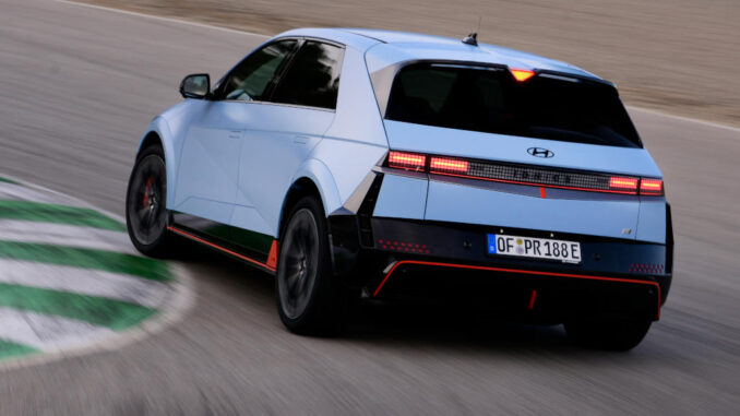 Ein blauer Hyundai Ioniq5N fährt 2024 auf einer Rennstrecke um die Kurve.