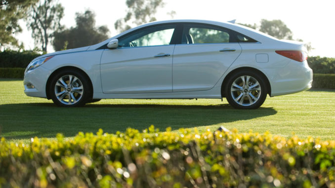 Ein weißer Hyundai Sonata des Modelljahres 2011 steht auf einer Rasenfläche.