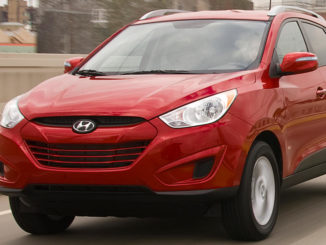 Ein roter Hyundai Tucson fährt 2012 über eine Brück einer amerikanischen Großstadt.