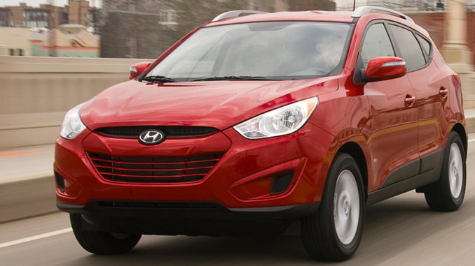 Ein roter Hyundai Tucson fährt 2012 über eine Brück einer amerikanischen Großstadt.