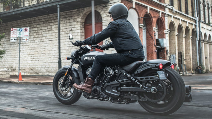 Eine schwarze Indian Scout Bobber des Modelljahres 2018 fährt durch eine amerikanische Innenstadt.