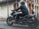 Eine schwarze Indian Scout Bobber des Modelljahres 2018 fährt durch eine amerikanische Innenstadt.