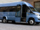 Ein blauer Iveco Daily Minibus steht vor einem Hotel.