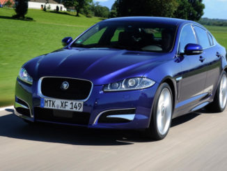 Ein blauer Jaguar XF fährt 2012 im Rahmen der Mille Miglia auf einer italienischen Landstraße.