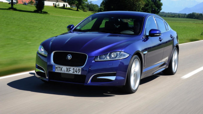 Ein blauer Jaguar XF fährt 2012 im Rahmen der Mille Miglia auf einer italienischen Landstraße.