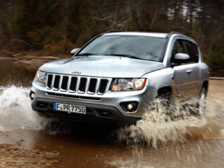 Ein silberner Jeep Compass fährt durch ein Flussbett