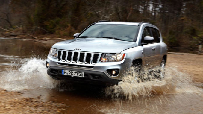 Ein silberner Jeep Compass fährt durch ein Flussbett