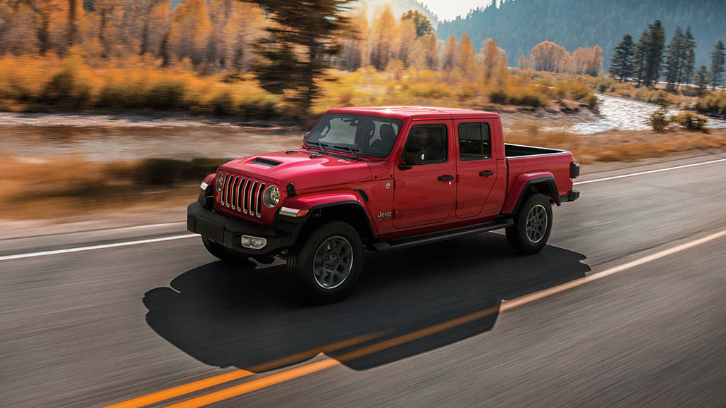 Ein roter Jeep Gladiator MY21 fährt auf einer US-amerikanischen Landstraße.