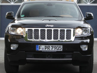 Ein schwarzer Jeep Grand Cherokee steht 2012 vor einer Villa.