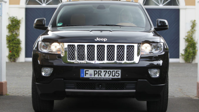 Ein schwarzer Jeep Grand Cherokee steht 2012 vor einer Villa.